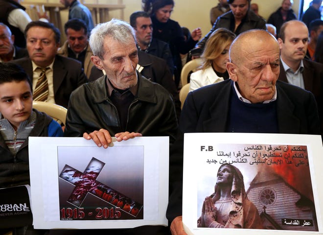 Assyrians citizens hold placards during a sit-in for abducted Christians in Syria and Iraq, at a church in Sabtiyesh area east Beirut, Lebanon, Thursday, Feb. 26, 2015. Islamic State militants snatched more hostages from homes in northeastern Syria over the past three days, bringing the total number of Christians abducted to over 220 in the one the largest hostage-takings by the extremist group, activists said Thursday. Arabic on the placard, right, reads, "you can burn the churches but you cannot burn our faiths, and in this faith we will rebuild the churches." (AP Photo/Hussein Malla)