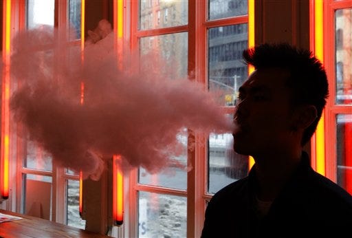 In this Feb. 20, 2014, File photo, a patron exhales vapor from an e-cigarette at the Henley Vaporium in New York. The first peek at a major study of how Americans smoke suggests many use combinations of products, and often e-cigarettes are part of the mix. It's a preliminary finding, but it highlights some key questions as health officials assess electronic cigarettes. (AP Photo/Frank Franklin II, File)