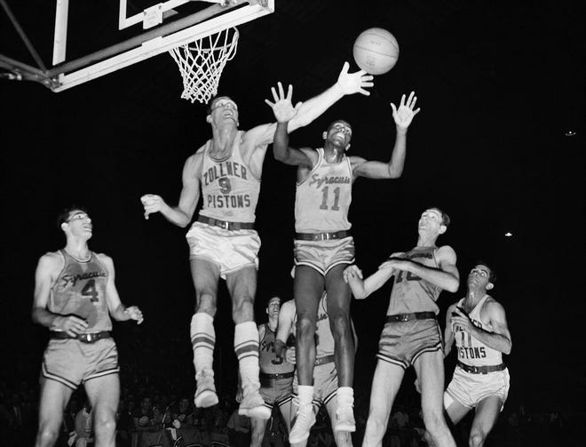 In this April 1955 file photo, Fort Wayne's Mel Hutchins (9) and Syracuse's Earl Lloyd (11) reach for the ball during an NBA basketball game in Indianapolis. Lloyd, the first black player in NBA history, died Thursday, Feb. 26, 2015. He was 86. Lloyd's alma mater, West Virginia State, confirmed the death. It did not provide details. Lloyd made his NBA debut in 1950 for the Washington Capitals, just before fellow black players Sweetwater Clifton and Chuck Cooper played their first games.