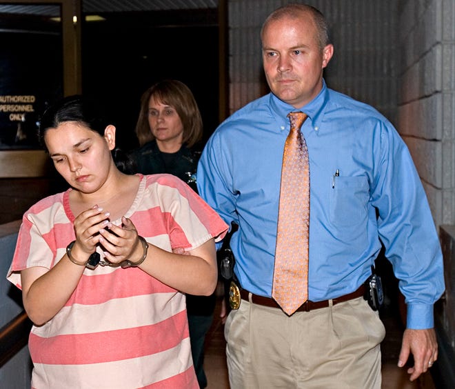 Marion County Sheriff's Detective Sgt. Brian Spivey walks Emilia Carr, 24, out of the MCSO's Operations Center after she and Joshua D. Fulgham, 27, was arrested on first-degree murder and kidnapping charges on March 24, 2009.