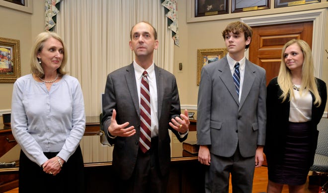 In this Jan. 12, 2015 photo, Tom Schweich, second from left, makes a few comments after his swearing-in ceremony in his Capitol office in Jefferson City. At left is his wife, Kathy, and to his right are son, Thomas Jr., and daughter Emile. Missouri Auditor Tom Schweich died Thursday morning of an apparent self-inflicted gunshot, police say.