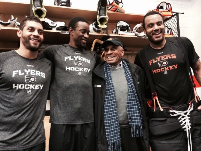 Willie O'Ree (second from right), the player who broke the NHL's color barrier in 1958, joins current Flyers (from left) Pierre-Edouard Bellemare, Wayne Simmonds and Ray Emery on Saturday in Philadelphia.
