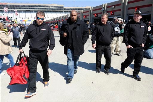 NASCAR driver Travis Kvapil's, not shown, crew members including owner John Cohen, second from left, leave the garage at Atlanta Motor Speedway Friday, Feb. 27, 2015, in Hampton, Ga. Kvapil's NASCAR Sprint Cup car was stolen early Friday.