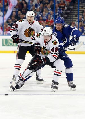 Chicago Blackhawks center Joakim Nordstrom (42), of Sweden, and defenseman Kyle Cumiskey (26) battle for the puck against Tampa Bay Lightning defenseman Anton Stralman (6), also of Sweden, during the third period of an NHL hockey game Friday, Feb. 27, 2015, in Tampa, Fla.