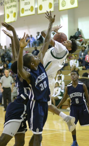 Kinston's Brandon Ingram (13) battles through multiple defenders in Saturday's playoff-opening win over North Carolina School of Science and Mathematics of Durham.