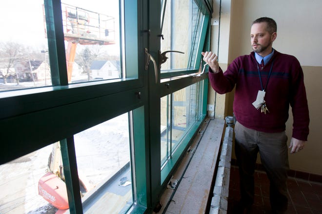 Principal Jason Grey talks Wednesday, Jan. 28, 2015, about a new window installed in the stairwell at Lincoln Middle School in Rockford. The window is one of two that are a test before upgrading all of the building's windows that are original from 1927. The new windows are energy efficient and will help control the climate of the building.