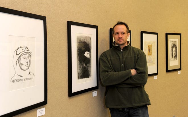 Artist John Schneider poses for a portrait near his work on display at Columbia College.