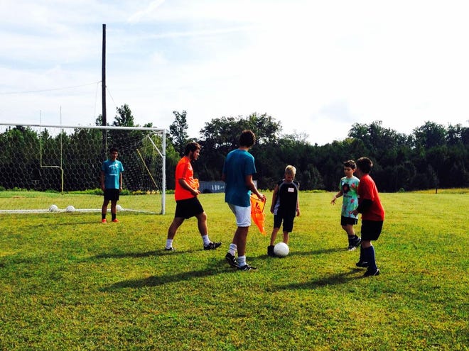 From left, Forestview varsity soccer players John Delgado, Jeff Friday and Cameron Kurtiak run soccer drills with ‘Let’s Play Soccer’ campers Joey Lipkin, Connor Mills and Zachary Cannon. Friday was named one of North Carolina’s seven finalists for the Prudential Spirit of Community Awards this year. The program honors young people from across the country for outstanding acts of volunteerism.