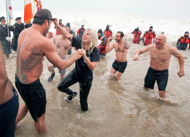 Actor Taylor Kinney, left, and his fiancée, pop star Lady Gaga, along with members of the "Chicago Fire" cast, take part in the Chicago Polar Plunge at North Avenue Beach on Sunday, March 1, 2015 in Chicago. (Photo by Barry Brecheisen/Invision/AP)