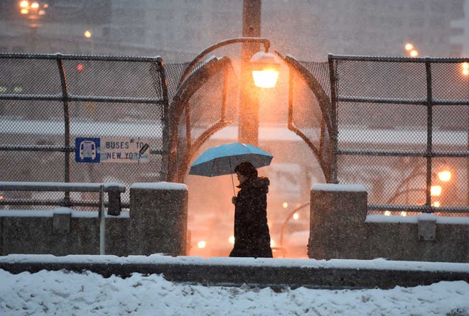 A pedestrian walks by as snow falls on the George Washington Bridge Sunday, March 1, 2015, in Bergen, N.J. (AP Photo/Northjersey.com, Tyson Trish) MANDATORY CREDIT, NO ARCHIVING ONLINE OUT, INTERNET OUT, FOR EDITORIAL USE ONLY