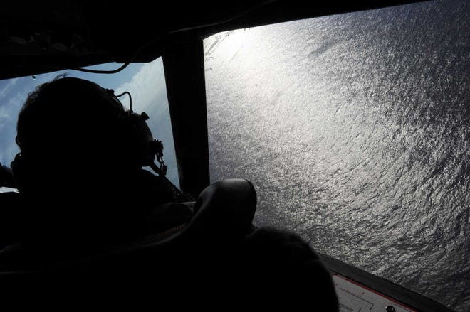 Associated Press file photoAboard the Royal New Zealand Air Force (RNZAF) P-3K2-Orion aircraft, co-pilot Squadron Leader Brett McKenzie looks out of a window in April 2014 while searching for debris from missing Malaysia Airlines Flight 370 over the Indian Ocean.