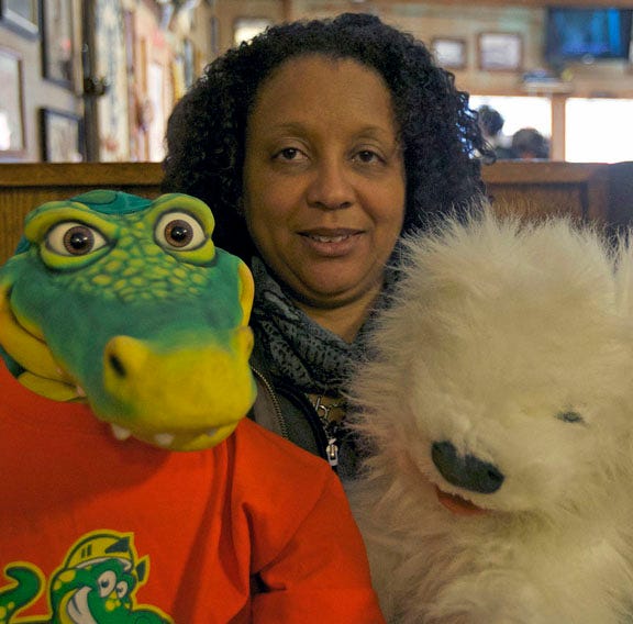 Pat Lambe poses with two of the puppets she uses to teach children history and values. She presented a program titled ‘Our Country, Our State’ at the N.C. History Center on Saturday.