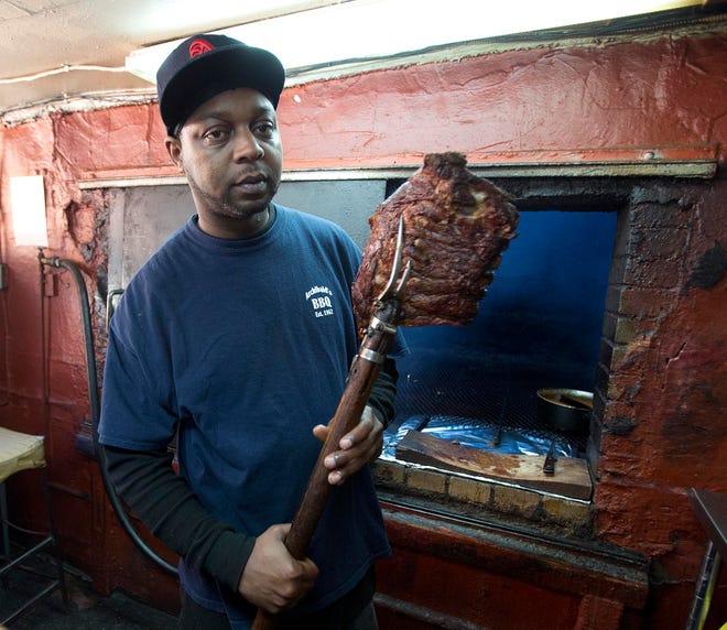 Demetrius Williams works at the pit in Archibald’s BBQ on Friday in Tuscaloosa. The restaurant is one of those featured in an essay called “Pork Ribs and Politics: The origins of Alabama barbecue” by University of Alabama doctoral student Mark Johnson.