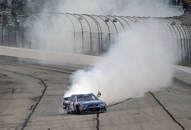 Jimmie Johnson does a burnout after winning the Sprint Cup Series race at Atlanta Motor Speedway on Sunday in Hampton, Ga.