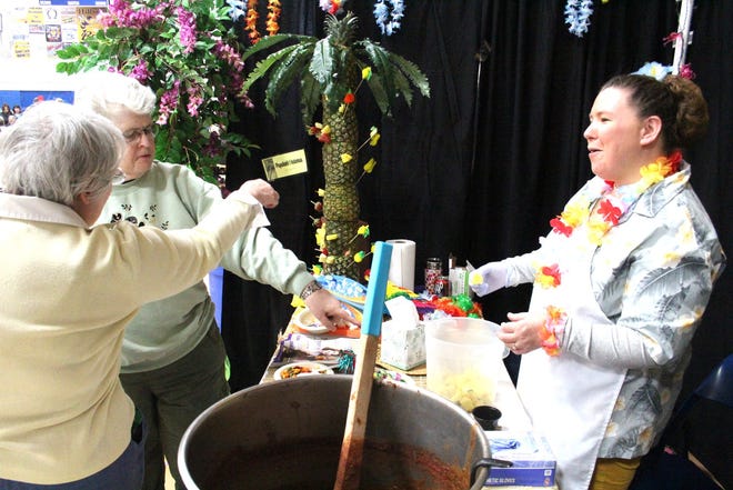 Perennial Park's Hawaiian-themed booth, replete with pineapple chili and manned by Jerri Blalock (far right), brought a unique flair to the cook-off floor. JASON DAFNIS PHOTO