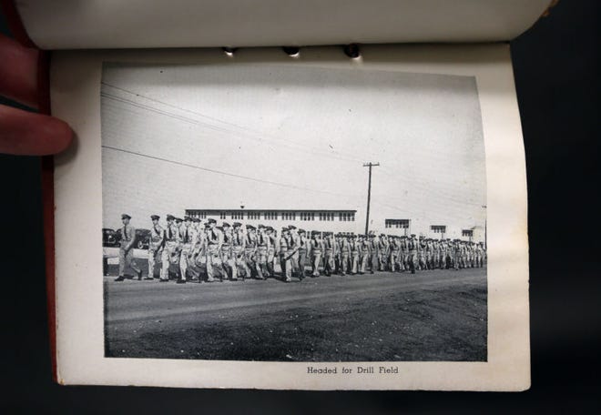 A photo inside the U.S. Naval Air Station photo booklet shows soldiers headed for the drill field.