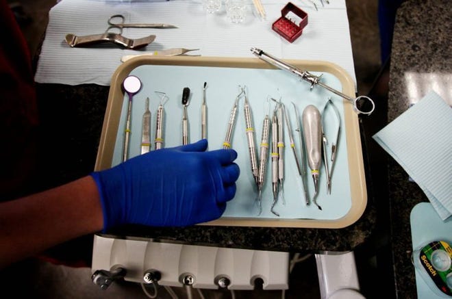 A dental assistant lays out tools for a tooth extraction in a dentist's office. CHRISTOPHER SMITH/Tulsa World file