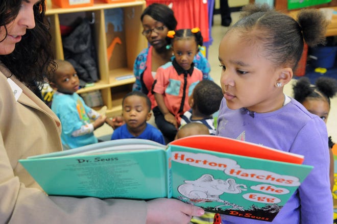 Jada Austin points to a picture in the book 'Horton Hatches the Egg' as read by Liz Johnson during a Read Across America Day event in 2014. United Way volunteers will once again read Dr. Seuss favorites with local kids today. Progress-Index File Photo