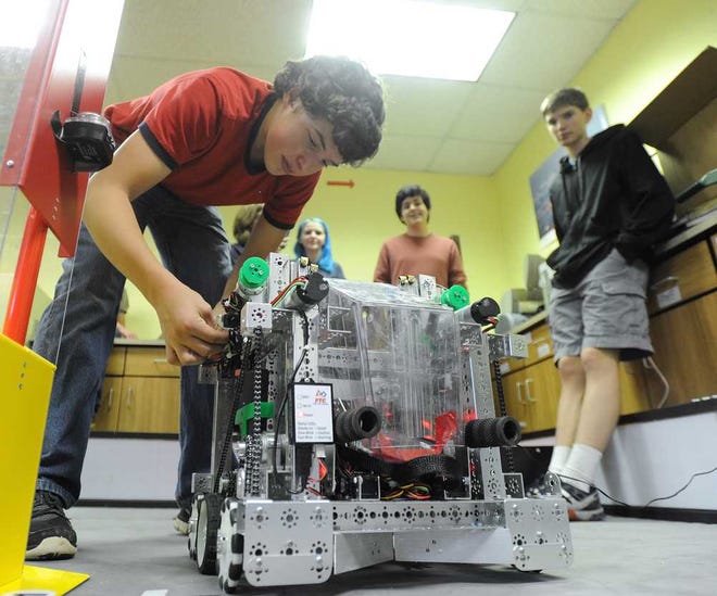 Marco Newman makes a few adjustments to the Robo Glads robot, Maximus, at Clarke Central High School on Tuesday, March 3, 2015 in Athens, Ga.  (Richard Hamm/Staff) OnlineAthens / Athens Banner-Herald