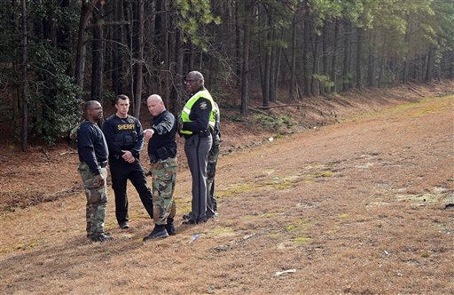 Wilson County Sheriff's Deputies investigate an area near Interstate 95, Monday, March 2, 2015, in Wilson, N.C. Armed robbers hijacked an armored truck, tied up the two guards and disappeared with 275 pounds of gold bars. (AP Photo/The Wilson Times, Brad Coville)