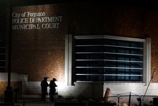 In this Nov. 26, 2014, file photo, nembers of Missouri National Guard stand outside of the Ferguson Police Department and the Municipal Court in Ferguson, Mo. A Justice Department investigation has found patterns of racial bias in the Ferguson police department and at the municipal jail and court. The full report, to be publicly released on March 4, says the investigation found Ferguson officers disproportionately used excessive force against blacks and too often charged them with petty offenses. (AP Photo/Jeff Roberson, File)