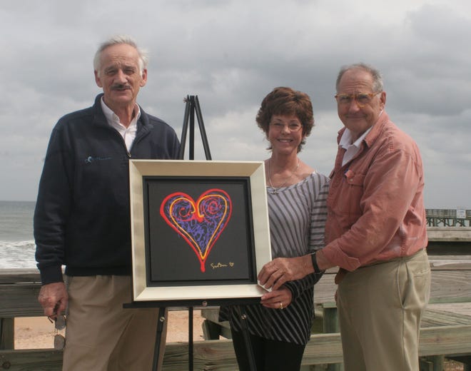 From left, Frank Gromling, owner of Ocean Art Gallery, along with Becki Smith and Jim Hain, of Marineland Right Whale Project, stand with a painting donated by artist Simon Bull. The painting will be raffled and the proceeds given to the Right Whale project.