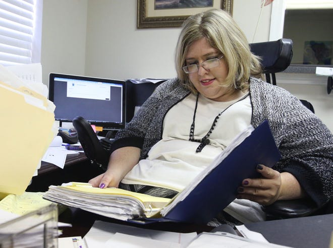 Amanda Baker looks over a file in her office. Baker has cerebral palsy and has fought for employment and other rights for people with disabilities.
