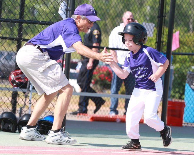 4/10/2012 -- Tuscaloosa, Ala -- Andrew Pate, age 7, is congratulated for hitting a homerun by his coach Jerry Mills at the LeeAnna Grace Cunningham field at Sokol Park in Tuscaloosa. Townsend and other kids with disabilities play at the park as apart of the Miracle League of Tuscaloosa.