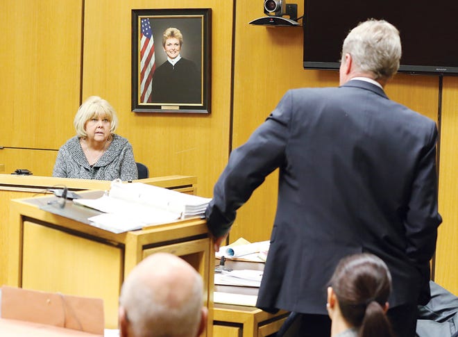 Assistant Lenawee County Prosecutor Douglas Hartung questions witness Barbara Minnick, the sister of murder victim Larry Kenneth Smith, during a preliminary examination Tuesday in Lenawee County District Court.