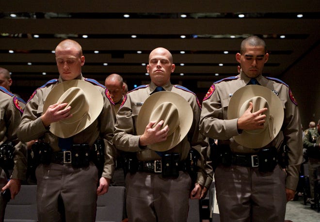 Three of 44 Department of Public Safety troopers graduating from cadet training pause for prayer on April 7, 2011.