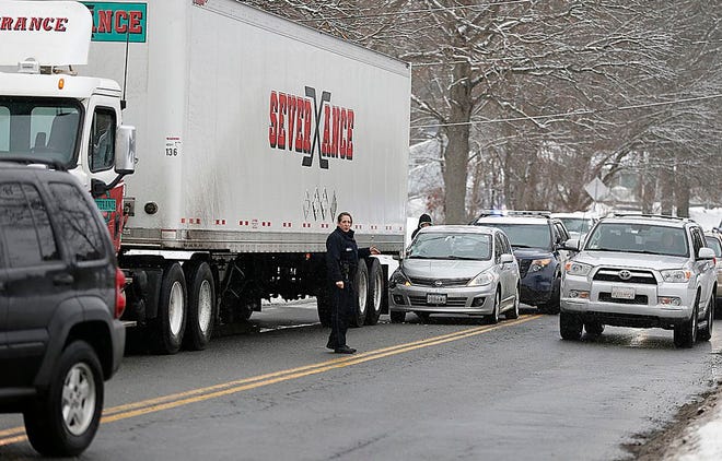 A Brockton Police Officer directs traffic around an accident at 820 Pearl St. due to the icy roads Thursday, March 5, 2015.