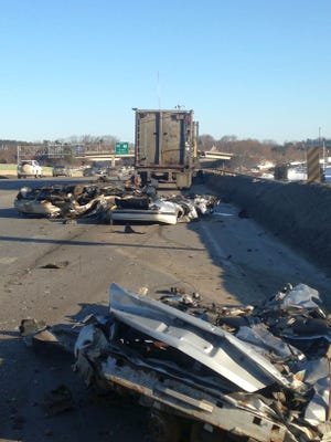 Debris from three crushed cars litters Interstate 295 in Portland, Maine, this morning after the vehicles fell off a truck from Rochester, N.H.