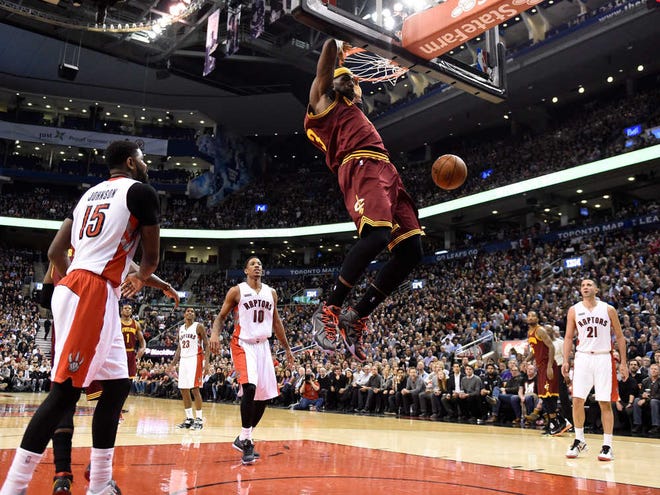 Cleveland Cavaliers' LeBron James (23) dunks as Toronto Raptors' Amir Johnson (15), DeMar DeRozan and Greivis Vasquez, right, watch during the second half of an NBA basketball game Wednesday, March 4, 2015, in Toronto. (AP Photo/The Canadian Press, Frank Gunn)
