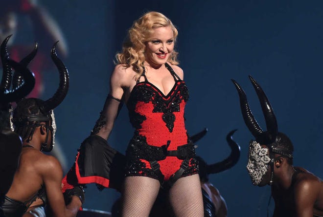 FILE - This Feb. 8, 2015 file photo shows Madonna performing at the 57th annual Grammy Awards in Los Angeles. The pop icon said in an interview Thursday, March 5, that being active saved her from serious injuries at the Brit Awards. The 56-year-old tumbled Feb. 25, during a live performance after her dancers tugged at her flowing cape, dragging her down three steps. Madonna said the cape had been tied too tightly at the neck, and after the performance, said she suffered whiplash. (Photo by John Shearer/Invision/AP)