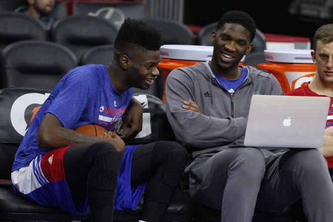 The 76ers' Joel Embiid, right, and Nerlens Noel share a laugh while looking at game film on a laptop prior to a Nov. 26 loss to the Nets.