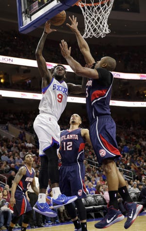 The 76ers' JaKarr Sampson (9) goes up for a shot as the Hawks' Al Horford (right) defends Saturday night.