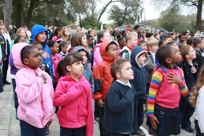Students at Lighthouse Christian Preparatory Academy recite the Pledge of Allegiance at the school’s first flag-raising ceremony.