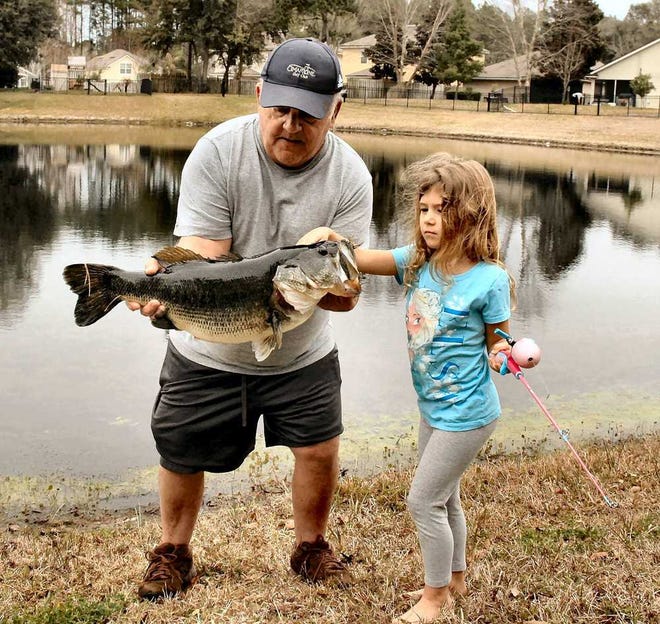 Mike "Pawpaw" Donahue of St. Johns County holds granddaughter SophieEvans first bass -- a massive fish caught from a retention pondestimated at over 12 pounds.credit linespecial to The Times-Union