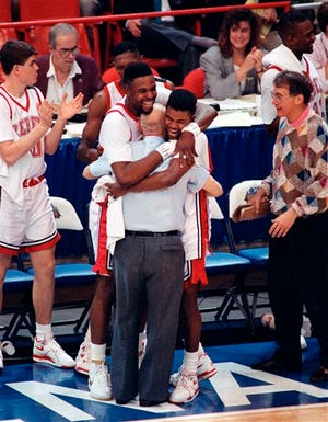 FILE - In this April 2, 1990, file photo, UNLV players Moses Scurry, left, and Anderson Hunt hug coach Jerry Tarkanian after the team's 103-73 victory over Duke in the NCAA college basketball tournament Final Four championship game in Denver. Hall of Fame coach Jerry Tarkanian, who built a basketball dynasty at UNLV but was defined more by his decades-long battle with the NCAA, died Wednesday, Feb. 11, 2015, in Las Vegas after several years of health issues. He was 84. (AP Photo/Susan Ragan, File)