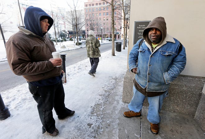 Ronald Brooks, left, and Jeffery Bailey wait for the doors to open at the Nashville Public Library. The men go to the library during bad weather for warmth, shelter, and something to do.