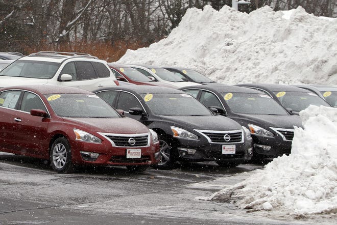 Cars share space with piled snow at an auto dealership in Marlborough, Mass. Analysts say lost sales should be made up as the weather warms.

AP Photo/Bill Sikes