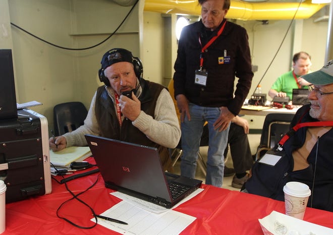Billy Robinson, of Whitman, Mass., talks with a radio operator from London as Fred Birtwell, center, and Mike Davis listen in as members of the Massasoit Amateur Radio Associaton provided a demontration Saturday for the Boy Scouts at the battleship Massachusetts in Fall River. The Providence Journal/Steve Szydlowski
