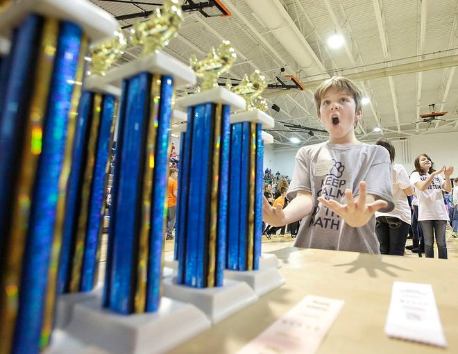 Jackson 5th grade student Jason Lutz looks over the first place trophies in anticipation of winning one as the testing period of the Stark County Math Tournament 2015 had concluded and the students attend a dance while the results are tallied.