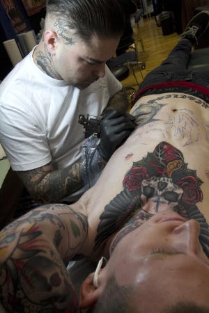 Blake Ellison of Eugene gets another tattoo from “Rest,” an artist with High Priestess Tattoo parlor in Eugene. (Amiran White/ For The Register-Guard)