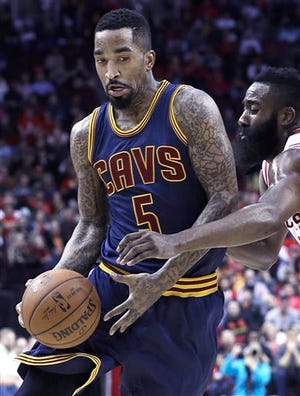 The Rockets' James Harden, right, tries to strip the ball from the Cavaliers' J.R. Smith (5) during a March 1 game in Houston. The Cavs lost 105-103 in overtime, running their streak to 14 consecutive losses in the state of Texas.