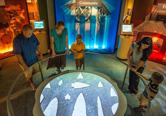 Visitors look at an arrowhead exhibit in the North Carolina History Center’s Regional History Museum.