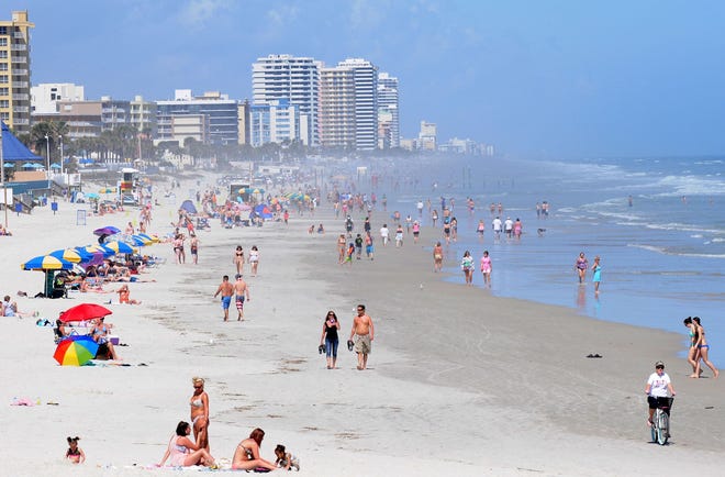 Visitors stroll along the Atlantic shoreline Tuesday in Daytona Beach.