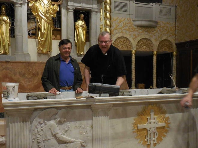 CONTRIBUTED Jimmy Pecorelli (left), construction supervisor for Baker Liturgical Art, and the Cathedral's rector, Fr. Tom Willis, place a time capsule into the main altar Monday morning.