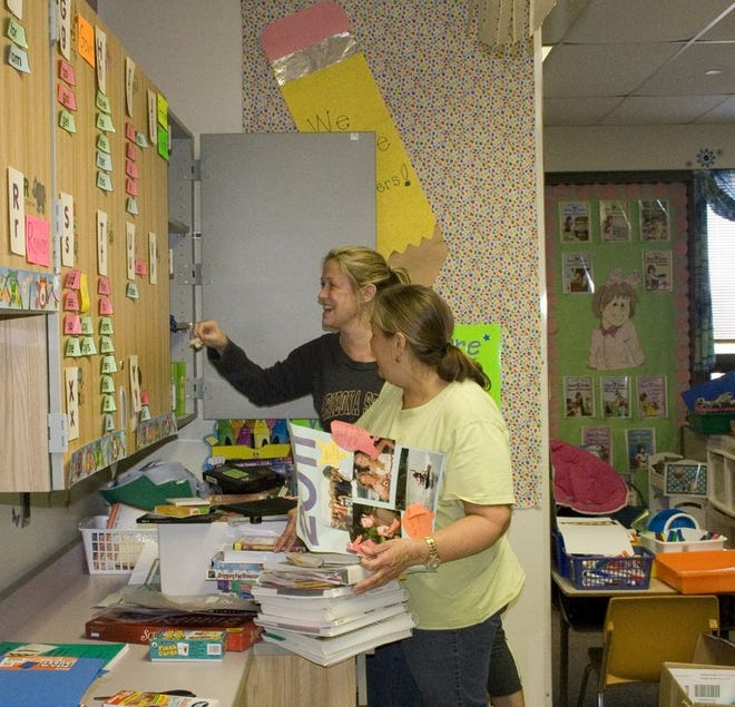 Kindergarten teacher Ronda Hoover and instructional assistant Trudy Buhrman worked on putting a Greencastle-Antrim Primary School classroom back in order Monday afternoon for the return of students today.