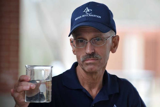 Scott Jones, an operator at the Middle Oconee Water Reclamation Facility, holds up a beaker of clean water at the end of the process at the facility on Thursday, March 12, 2015, in Athens Ga. (AJ Reynolds/Staff, @ajreynoldsphoto)